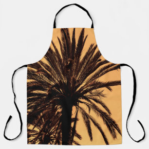 Dark silhouettes of date palms against bright colo apron