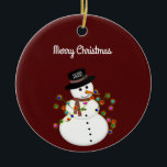 Dated Merry Christmas Snowman Personalised Ceramic Ornament<br><div class="desc">Cute snowman is tangled with lit Christmas lights, has the year on his hat - The "Merry Christmas" text above can be changed or added to, and the font style/size can also be changed. Shown on a deep red background, which can be changed to any colour you prefer. The ornament...</div>