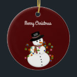 Dated Merry Christmas Snowman Personalised Ceramic Ornament<br><div class="desc">Cute snowman is tangled with lit Christmas lights, has the year on his hat - The "Merry Christmas" text above can be changed or added to, and the font style/size can also be changed. Shown on a deep red background, which can be changed to any colour you prefer. The ornament...</div>