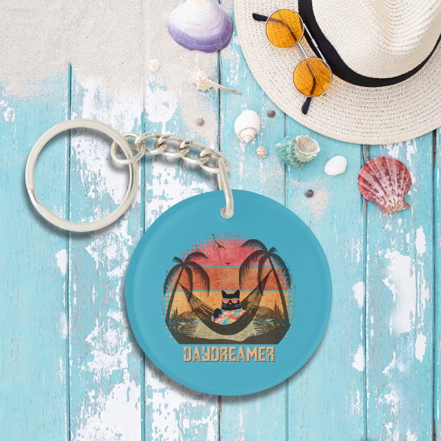 Daydreaming Cool Cat's Tropical Escape Round Key Ring (A Daydreaming Cool Cat's Tropical Escape Round Keychain on the table.)