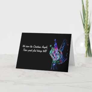 Depicts a lighted angel blowing a trumpet  holiday card