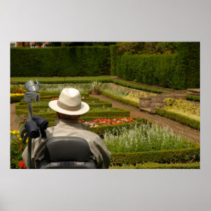 Disabled man in wheelchair in garden poster