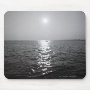 Distant boat on ocean mouse pad