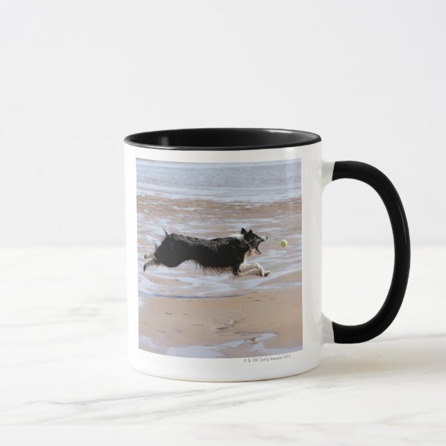 Dog chasing a ball at the beach mug (Right)