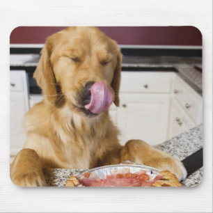 Dog licking nose after eating cherry pie in mouse pad