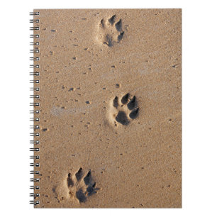 Dog paw prints on a sandy beach notebook