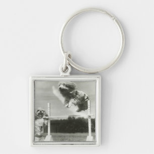 Dogs jumping over miniature high jump bar key ring