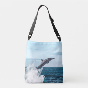 Dolphin leaping out of the ocean crossbody bag