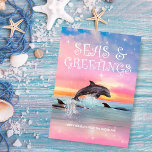 Dolphin Seas & Greetings Tropical Beach Christmas Holiday Card<br><div class="desc">Send some warm wishes to family and friends this holiday season with this beach theme Christmas card featuring a dolphin leaping out of the ocean under a colorful tropical sunset and a nautical "Seas & Greetings" caption. Art by KL Stock.</div>