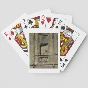 Dummy window in the entrance facade with a figure playing cards