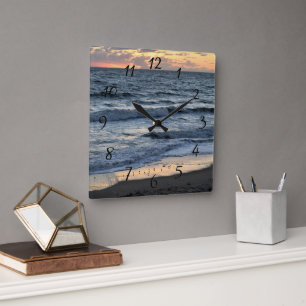 Early morning sunrise over the ocean square wall clock