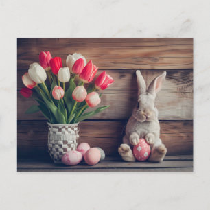 Easter bunny seated beside colorful eggs and tulip postcard