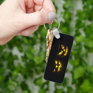 Eerie yellow glow pumpkin faces on black long key ring