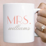 Elegant Blush Mrs Wedding Monogram Coffee Mug<br><div class="desc">This refined Mrs mug features oversized elegant serif typography in soft blush with a custom last name in delicate script beneath. The minimalist design on a clean white background creates a timeless, feminine look. The last name is fully editable for a personalised keepsake. A beautiful gift for the bride, newlywed,...</div>