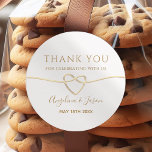 Elegant Gold Wedding Thank You Sticker<br><div class="desc">Add a touch of elegance to your wedding favours with this classic round thank you sticker. Featuring a minimalist gold script with a heart-shaped rope design and personalised names,  it’s the perfect way to thank your guests in style. Ideal for cookie bags,  boxes,  or custom wedding favours.</div>