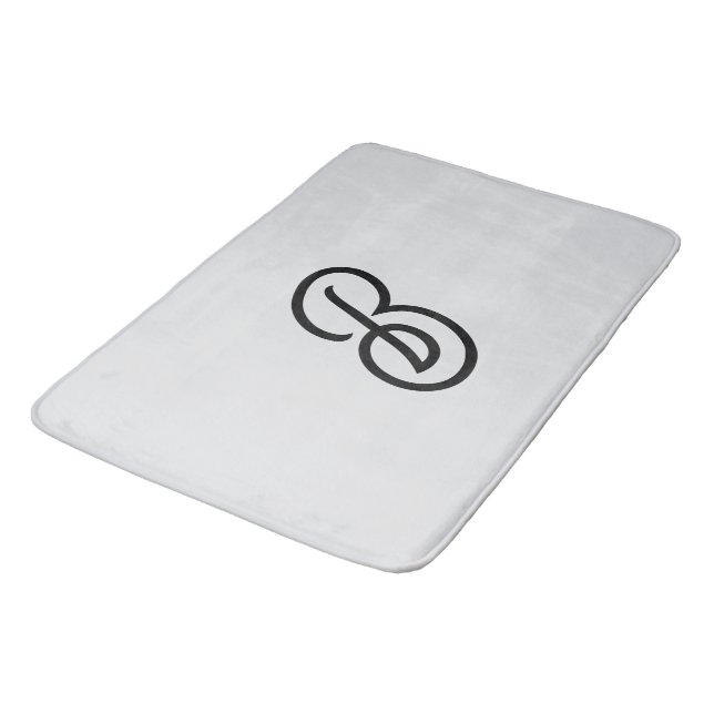 Elegant minimalist modern initial on grey bath mat (Angled)