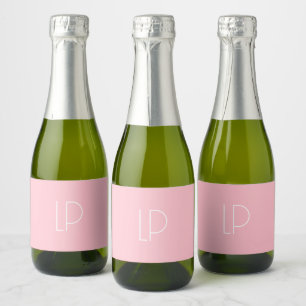 Elegant minimalist modern initial on pastel pink sparkling wine label