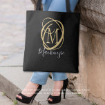 Elegant Stylish Monogram Script Name Black Gold Tote Bag<br><div class="desc">Elegant, modern, stylish tote bag personalised with a decorative monogram or initial in gold with a trendy handwritten script name in white against an editable black background. CHANGES: Change the background colour, choose a style graphic background or change the text font style, colour, size and placement by clicking on CUSTOMIZE...</div>