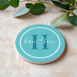Elegant Teal Blue Round Custom Monogram Initial Coaster<br><div class="desc">Elegant round personalised beverage drink coaster design features a classic custom serif monogram initial in a teal green blue colour with your last name in modern white calligraphy script against an aqua blue coloured background. A simple white circle frames the design. Colour scheme can be customised to coordinate perfectly with...</div>