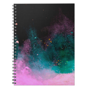 Explosion of coloured powder isolated on black bac notebook