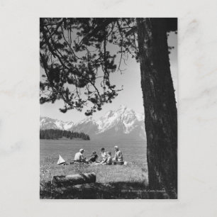 Family having picnic by lake mountains postcard