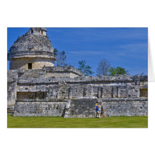 Family of tourists walk past ancient Mayan