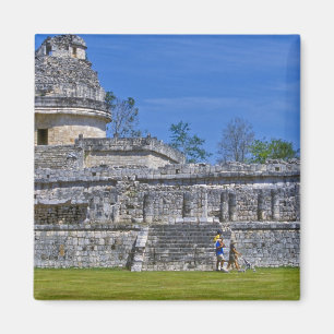 Family of tourists walk past ancient Mayan Magnet
