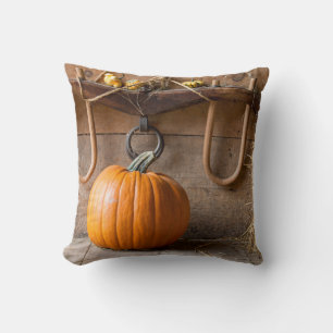 Farmers Museum. Pumpkin in barn with bale of hay Cushion