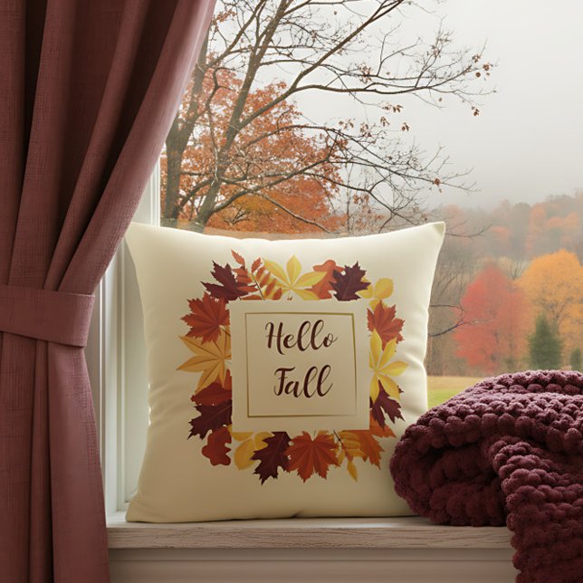 Farmhouse Hello Fall Accent with Rustic Leaves Cushion ("Hello Fall” pillow with autumn leaf wreath decorates a window with colorful fall view.)