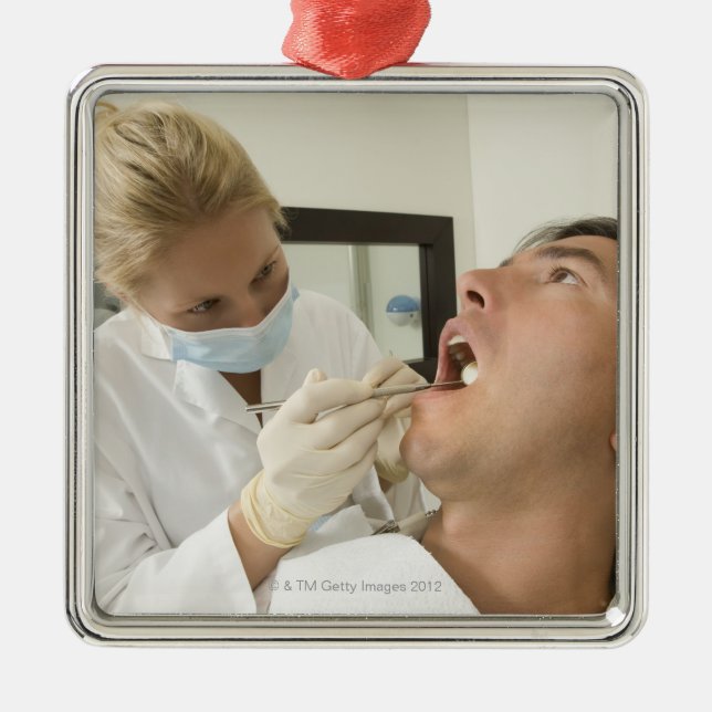 Female dentist examining man metal tree decoration (Front)