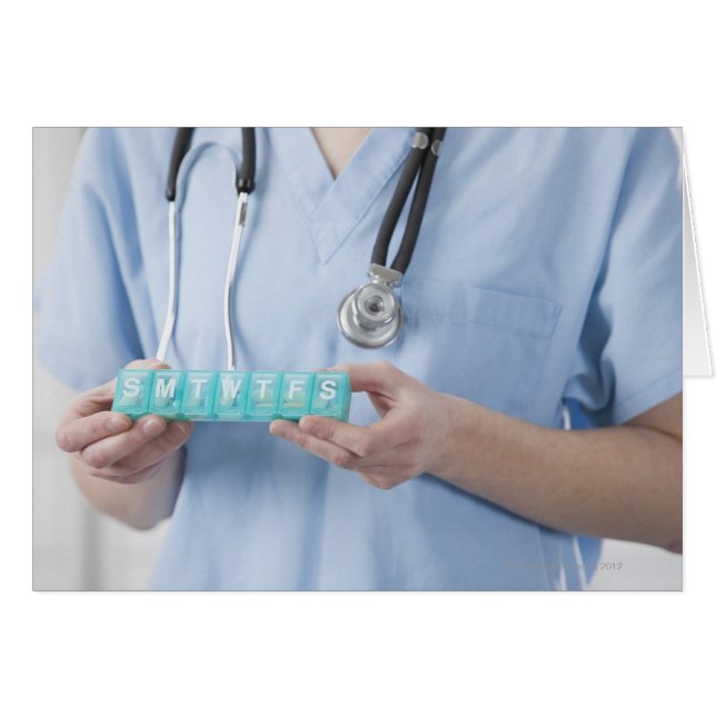 Female doctor holding pill box, mid section (Front Horizontal)