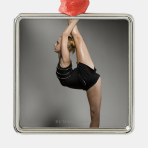 Female gymnast stretching, studio shot metal ornament