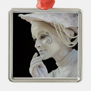 Female mime performing on street corner metal tree decoration