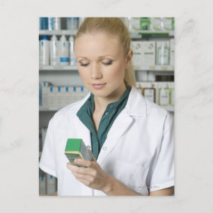 Female pharmacist looking at medicine in postcard