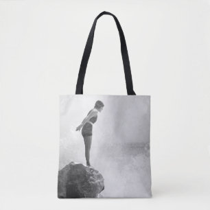 Female swimmer on rock above crashing surfvintage, tote bag