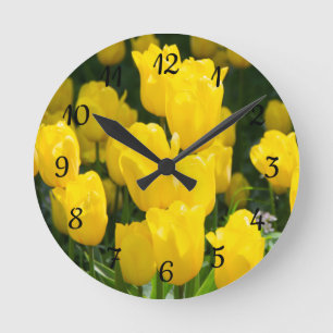 Field of bright yellow tulips round clock