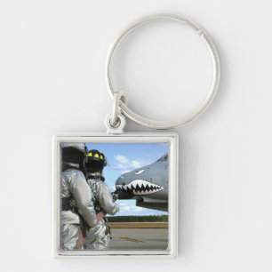 Firefighters deploy a fire hose during a drill key ring