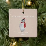 First Christmas Baby Penguin Pink Snow Ceramic Ornament<br><div class="desc">Illustration of a baby penguin wearing a santa hat and matching scarf surrounded by snowflakes with a light pink background.  Text says,  "My first Christmas."  Personalise the name and year.</div>