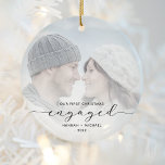 First Christmas Engaged Custom Photo Black Script Ceramic Ornament<br><div class="desc">Commemorate your engagement with this beautiful modern keepsake ornament. The black text reads "Our first Christmas engaged, " with the word "engaged" in elegant script with swashes before and after. Replace the sample image with your favourite photo, and add your names and the year. A white gradient filter helps make...</div>