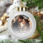 First Christmas Engaged Custom Photo Grey Script Ceramic Ball Christmas Ornament<br><div class="desc">Commemorate your engagement with this beautiful modern keepsake ornament. The charcoal grey text reads "Our first Christmas engaged, " with the word "engaged" in elegant script with swashes before and after. Replace the sample image with your favourite photo, and add your names and the year. A white gradient filter helps...</div>
