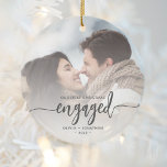 First Christmas Engaged Custom Photo Grey Script Ceramic Ornament<br><div class="desc">Commemorate your engagement with this beautiful modern keepsake ornament. The charcoal grey text reads "Our first Christmas engaged, " with the word "engaged" in elegant calligraphy script with decorative swashes before and after. Replace the sample image with your favourite photo, and add your names and the year. A white gradient...</div>