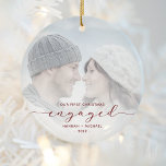 First Christmas Engaged Custom Photo Red Script Ceramic Ornament<br><div class="desc">Commemorate your engagement with this beautiful modern keepsake ornament. The burgundy red text reads "Our first Christmas engaged, " with the word "engaged" in elegant script with swashes before and after. Replace the sample image with your favourite photo, and add your names and the year. A white gradient filter helps...</div>