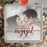 First Christmas Engaged Custom Photo Red Script Metal Ornament<br><div class="desc">Commemorate your engagement with this beautiful modern keepsake ornament. The burgundy red text reads "Our first Christmas engaged, " with the word "engaged" in elegant calligraphy script with decorative swashes before and after. Replace the sample image with your favourite photo, and add your names and the year. A white gradient...</div>