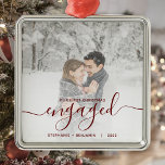 First Christmas Engaged Custom Photo Red Script Metal Ornament<br><div class="desc">Commemorate your engagement with this beautiful modern keepsake ornament. The dark red text reads "Our first Christmas engaged, " with the word "engaged" in elegant handwriting script with flourishes before and after. Replace the sample image with your favorite photo, and add your names and the year. A white gradient filter...</div>