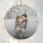 First Christmas Engaged Custom Photo White Script Ceramic Ornament<br><div class="desc">Commemorate your engagement with this beautiful modern keepsake ornament. The white text reads "Our first Christmas engaged, " with the word "engaged" in elegant handwriting script with flourishes before and after. Replace the sample image with your favourite photo, and add your names and the year. A dark gradient filter helps...</div>