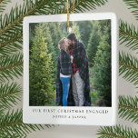 First Christmas Engaged | Minimal Engagement Photo Ceramic Ornament<br><div class="desc">A stylish minimal photo holiday christmas tree ornament with classic typography "Our first christmas engaged" in black on a clean simple minimalist white background. The photo, greeting and name can be easily customised for a personal touch. A simple, minimalist and contemporary christmas design to announce your engagement to your loved...</div>