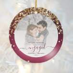 First Christmas Engaged Photo Burgundy Gold Ceramic Ornament<br><div class="desc">Commemorate your engagement with this beautiful modern keepsake photo ornament. The burgundy text reads "Our first Christmas engaged, " with the word "engaged" in elegant faux foil script with flourishes before and after. The border features a burgundy faux foil design sprinkled with sparkling gold faux glitter. Replace the sample image...</div>