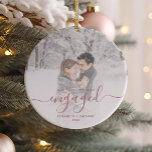 First Christmas Engaged Photo Dusty Rose Script Ceramic Ornament<br><div class="desc">Commemorate your engagement with this beautiful modern keepsake ornament. The text reads "Our first Christmas engaged, " with the word "engaged" in elegant dusty rose handwriting script with flourishes before and after. Replace the sample image with your favourite photo, and add your names and the year. A white gradient filter...</div>