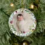 First Christmas Green Holiday Wreath Baby Photo Ceramic Ornament<br><div class="desc">This elegant two-sided holiday photo keepsake ornament features a newborn photo of your baby girl framed by a floral watercolor holiday greenery wreath. The back of the ornament includes "First Christmas" wording with custom text that can be personalised with the baby's full name and the year of their birth. Includes...</div>