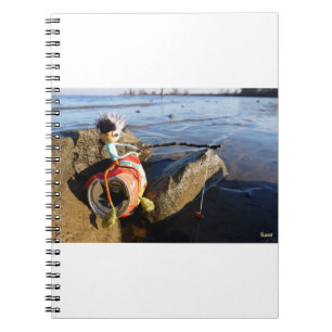 Fishing Fubby on a can at the water side. Notebook
